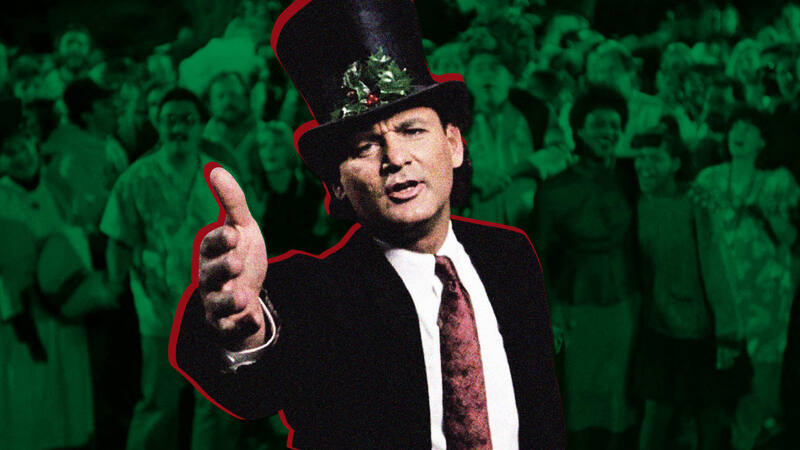 Bill Murray stands with his hands out wearing a black suit and a festive top hat.